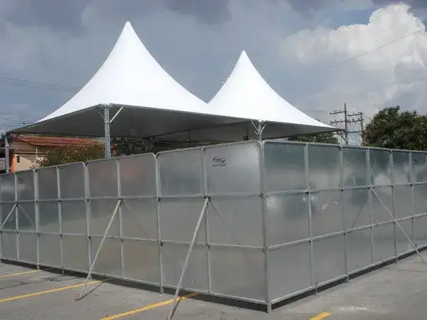 Fechamento metálico modular com tendas pagode ao fundo — referência